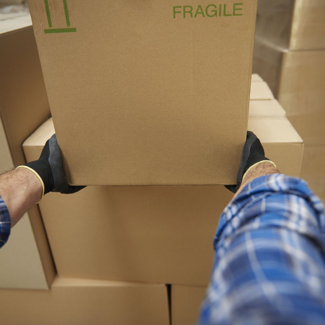 A man getting ready to safely lift a heavy box.